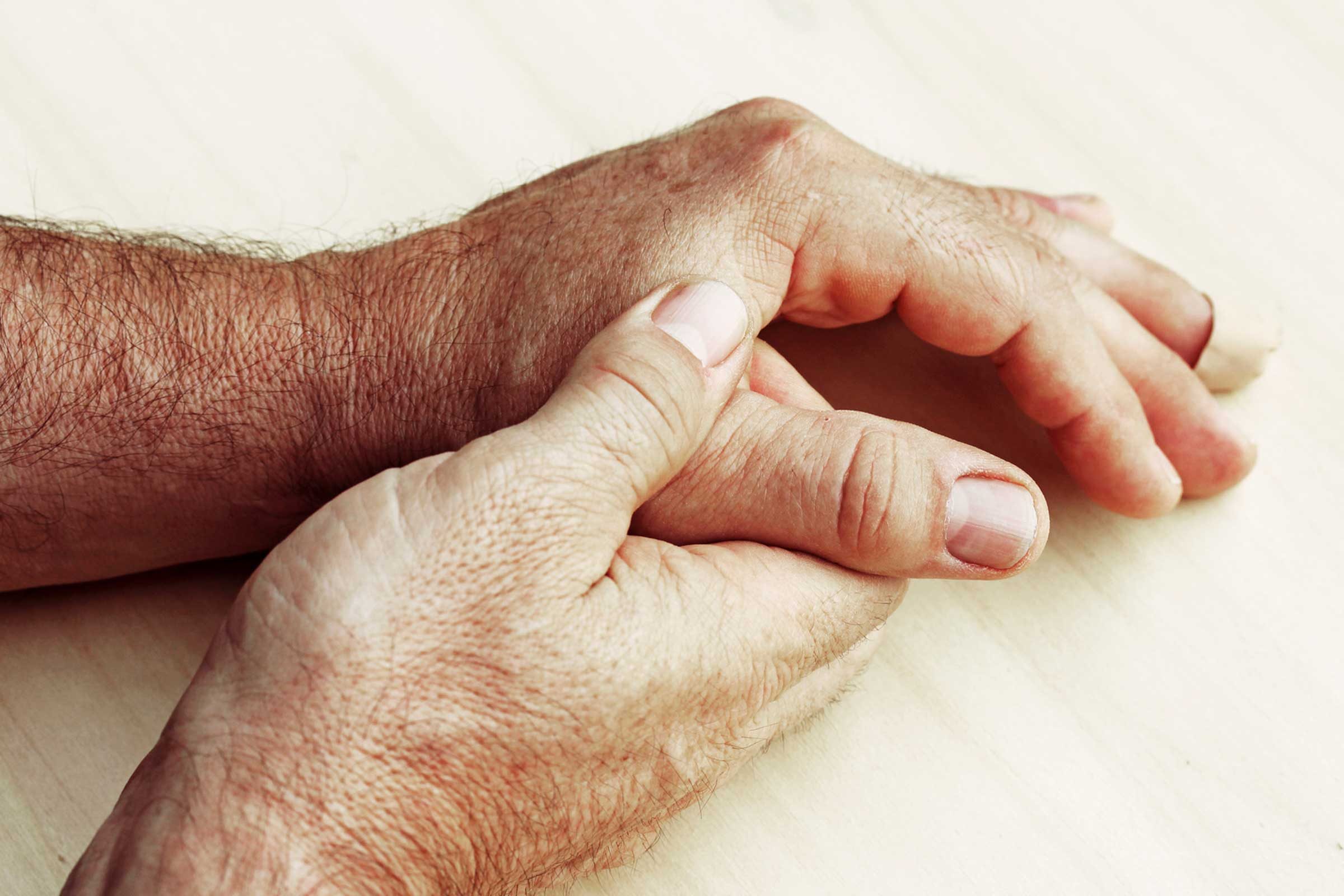 man massaging his thumb joint