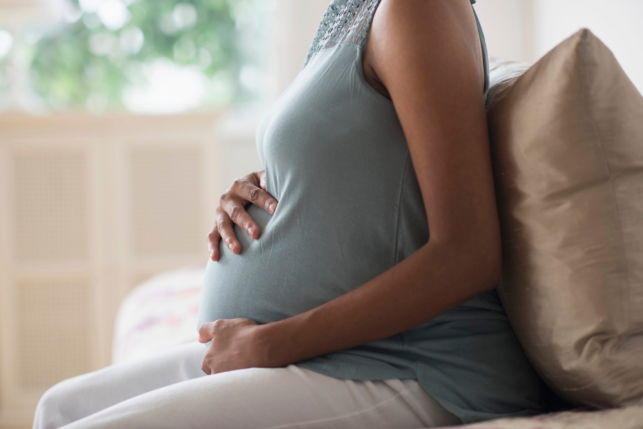 cropped close up shot of pregnant woman holding her stomach