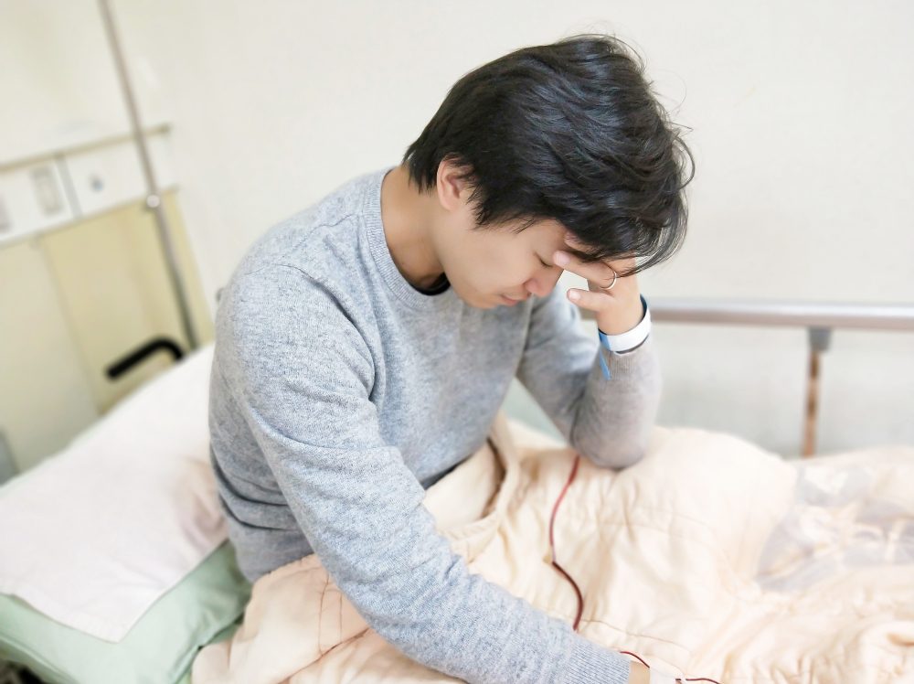 patient man with headache on the hospital bed 
