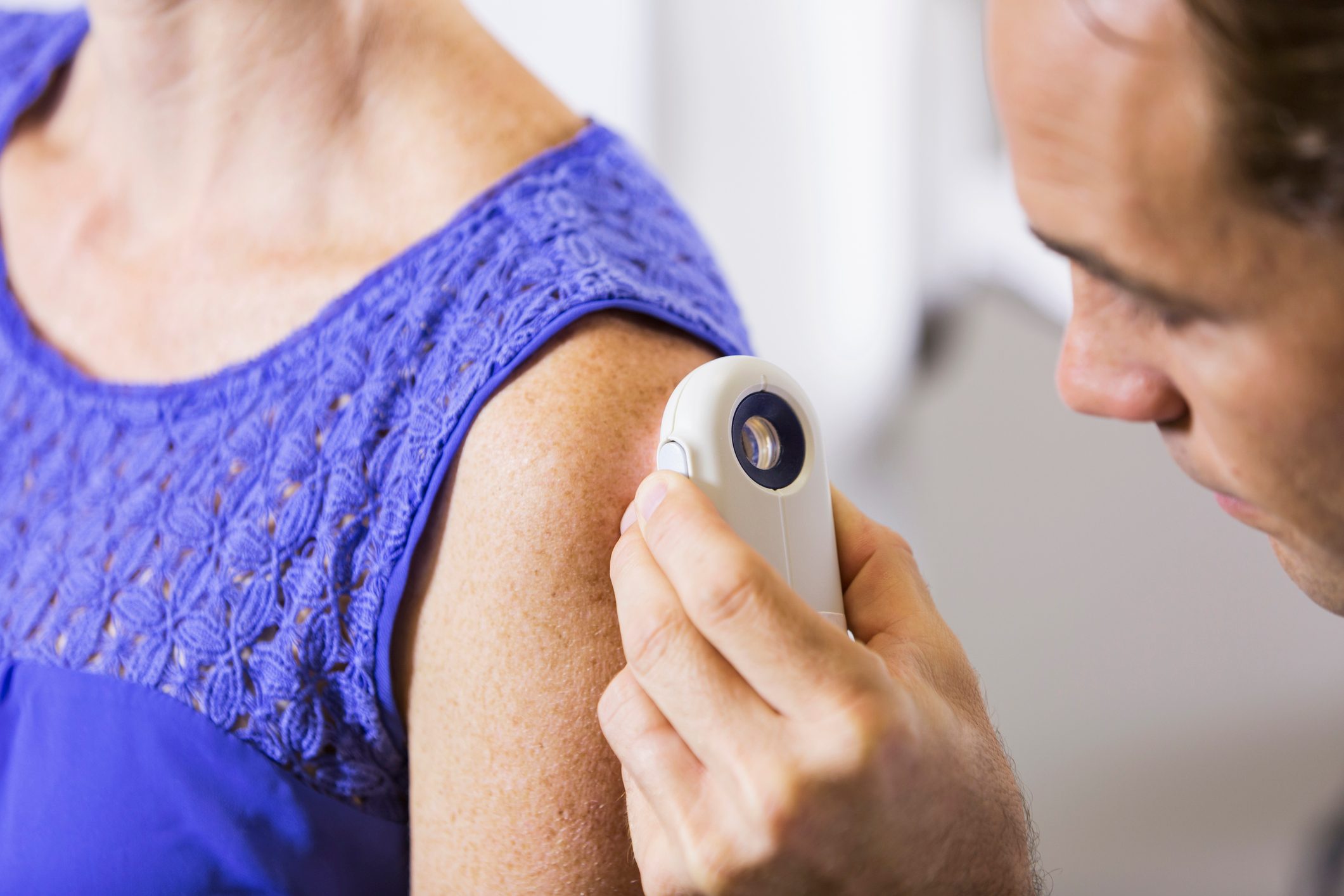 dermatologist examining woman's skin