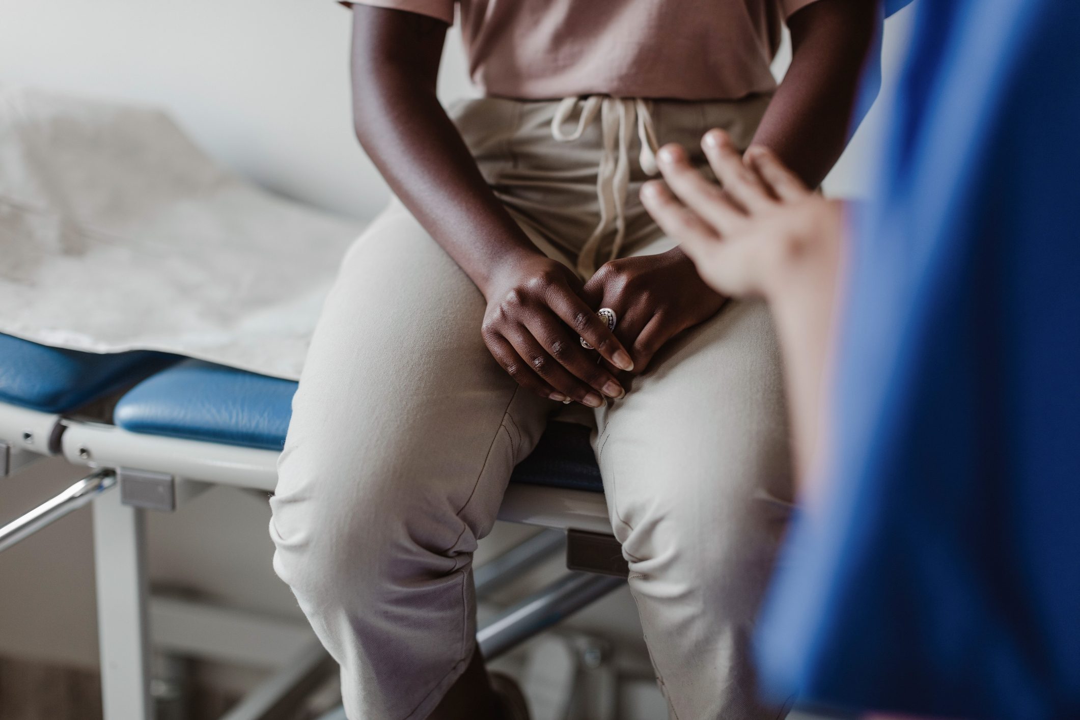 Midsection of female healthcare worker talking to patient