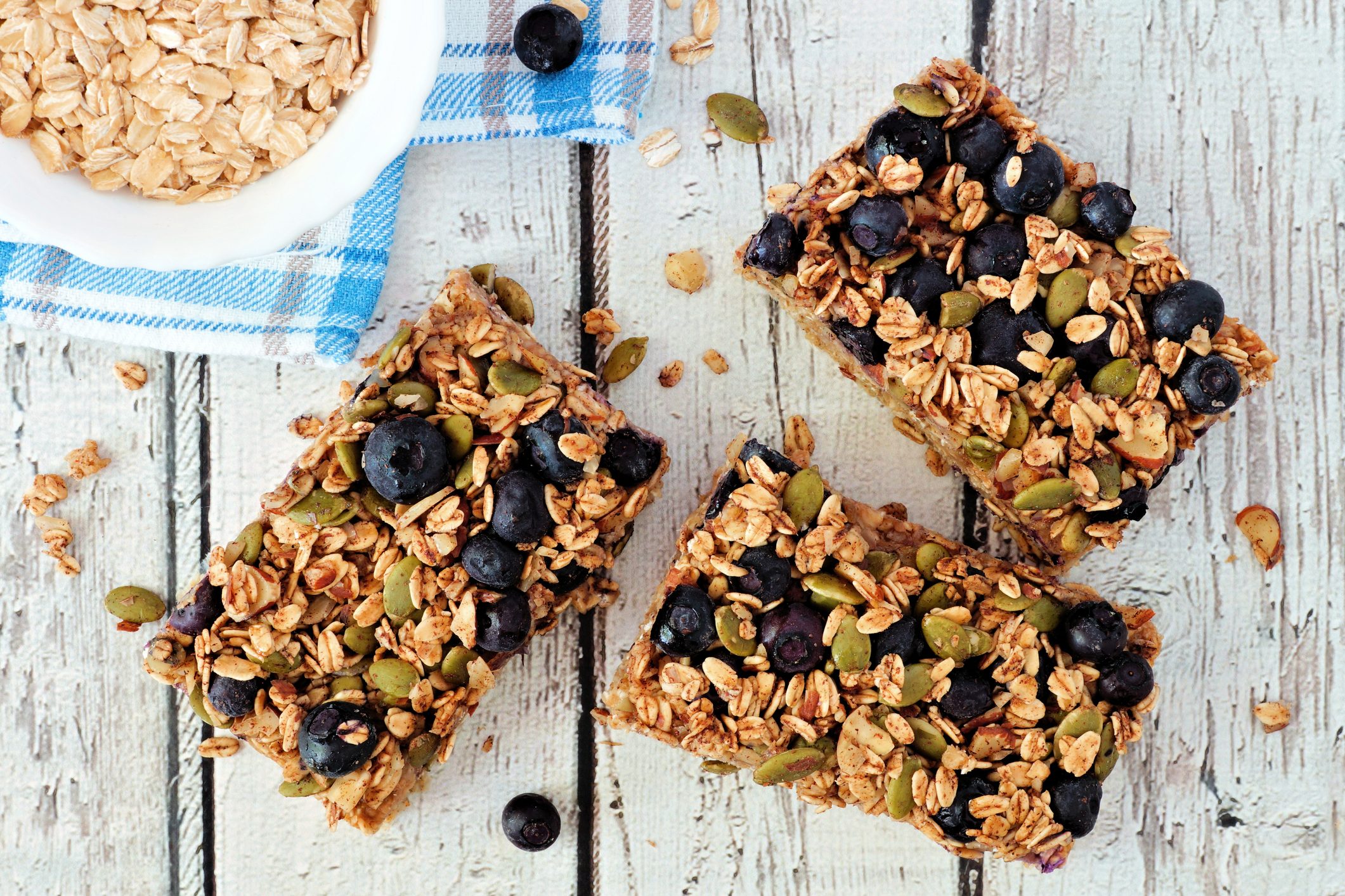 Superfood breakfast bars, overhead on white wood