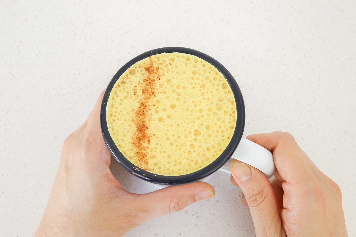 hands holding a cup of golden milk