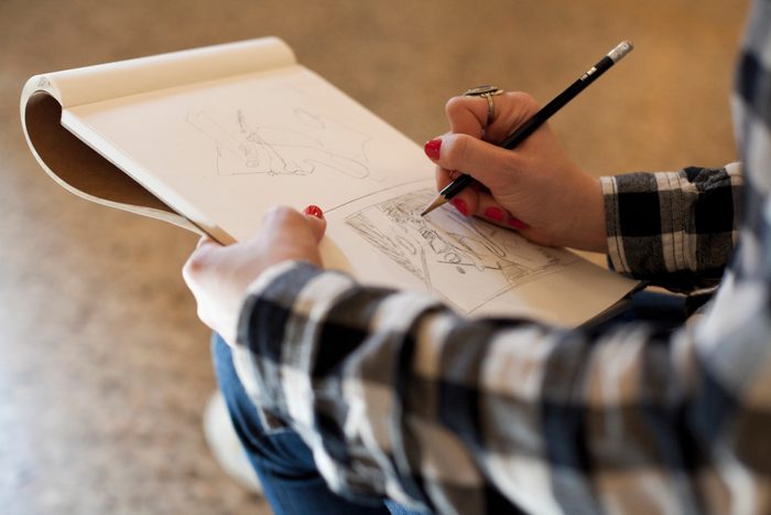 art student with sketchbook, close-up of hands